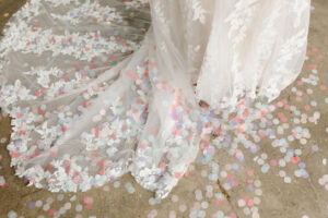 beautiful white lace wedding dress skirt and train, surrounded by confetti