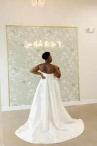 woman showing the train of an ivory satin wedding dress