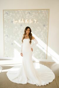 bride in front of wallpaper wall in a clean fitted dress