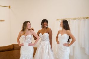 Three Ivoryology brides laughing together while wearing their wedding dresses.